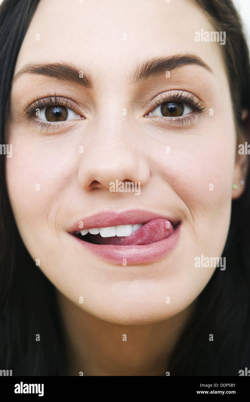 Young woman licking her lips in anticipation & pleasure Stock Photo