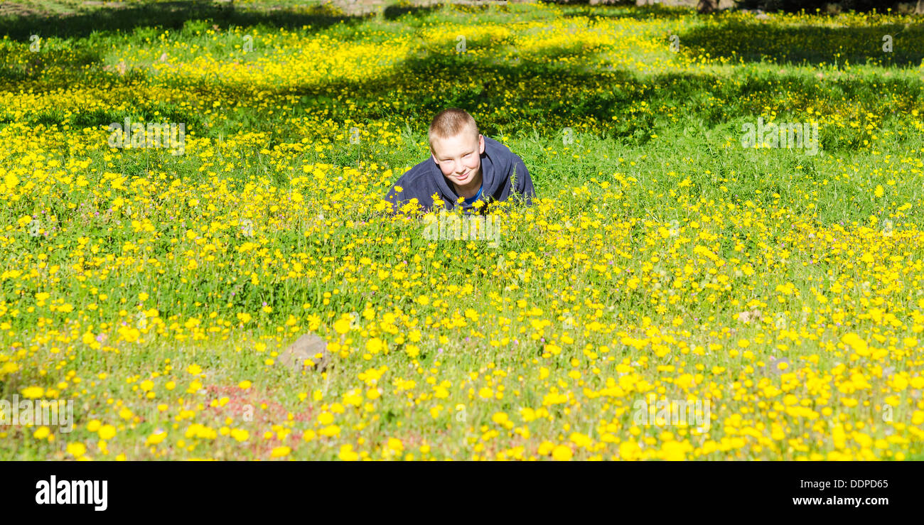 Attractive resting kid lay on the fresh spring meadow Stock Photo