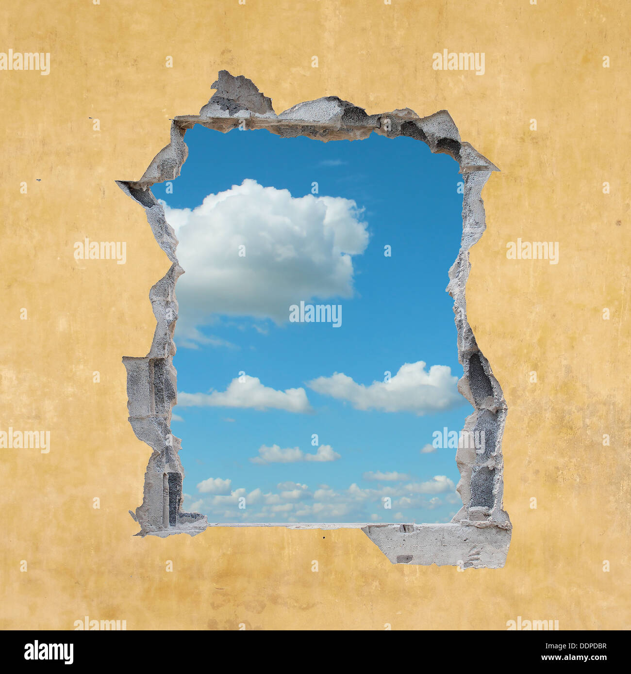 A Hole in a Wall with Blue Sky Stock Photo