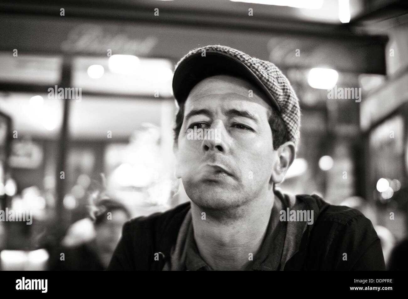 A french man in parisian cafe bar smoking and looking philosophical