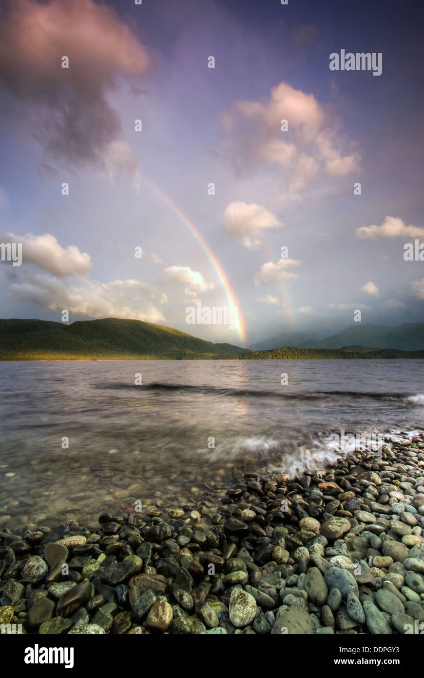 Rainbows over Fiordland mountains and Lake Te Anau at dawn.  South Island, New Zealand Stock Photo