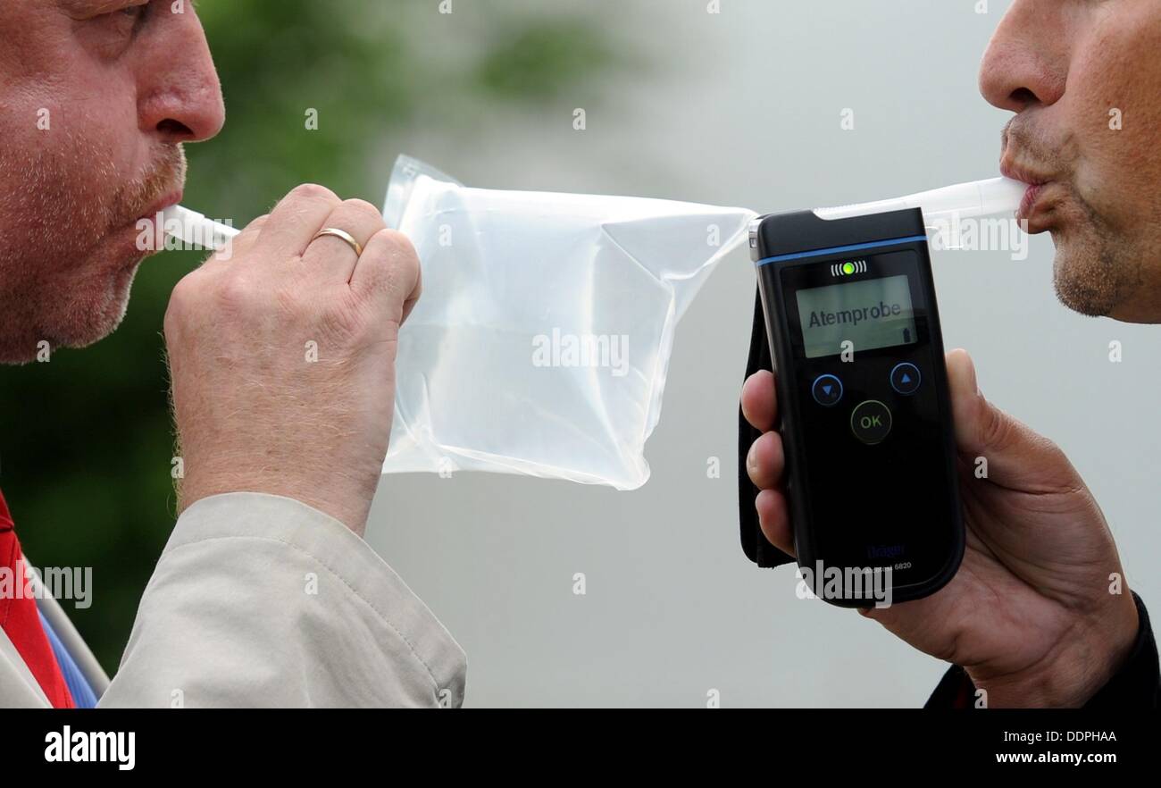 Product manager Juergen Sohege (L) and project manager Mirco Spitzbarth demonstrate first generation (L) and current model (R) portable alcohol testing devices made by the Draeger company in Luebeck, Germany, 22 August 2013. For 60 years, Draeger has been providing alcohol testing devices all over the world. Photo: Carsten Rehder Stock Photo
