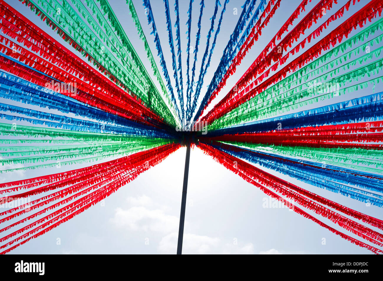 Red green and blue bunting hangs from a support pole against the sky ready for the fiesta in Playa San Juan, Tenerife, Stock Photo