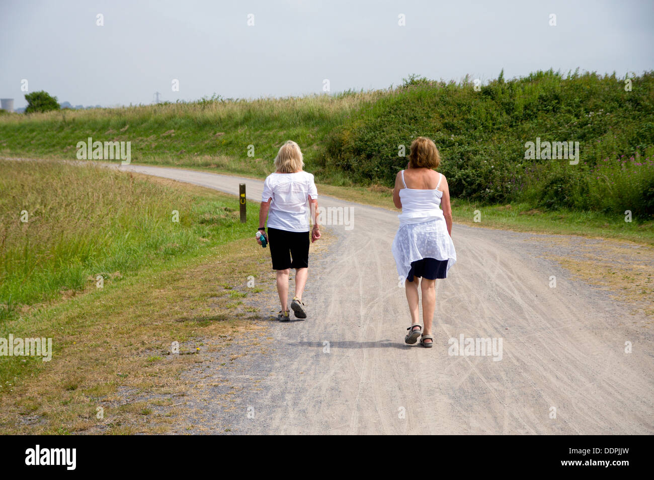 Two women walking along Millennium coastal path, Machynys, Llanelli, Carmarthenshire, West Wales. Stock Photo