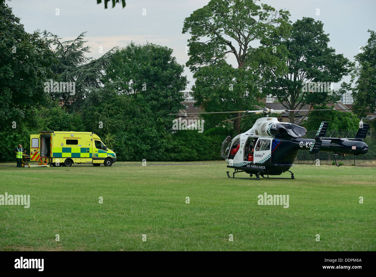 Medical Aviation Services Air Ambulance with a proper ambulance in the background, assisting with an injury in one of many London parks. Stock Photo
