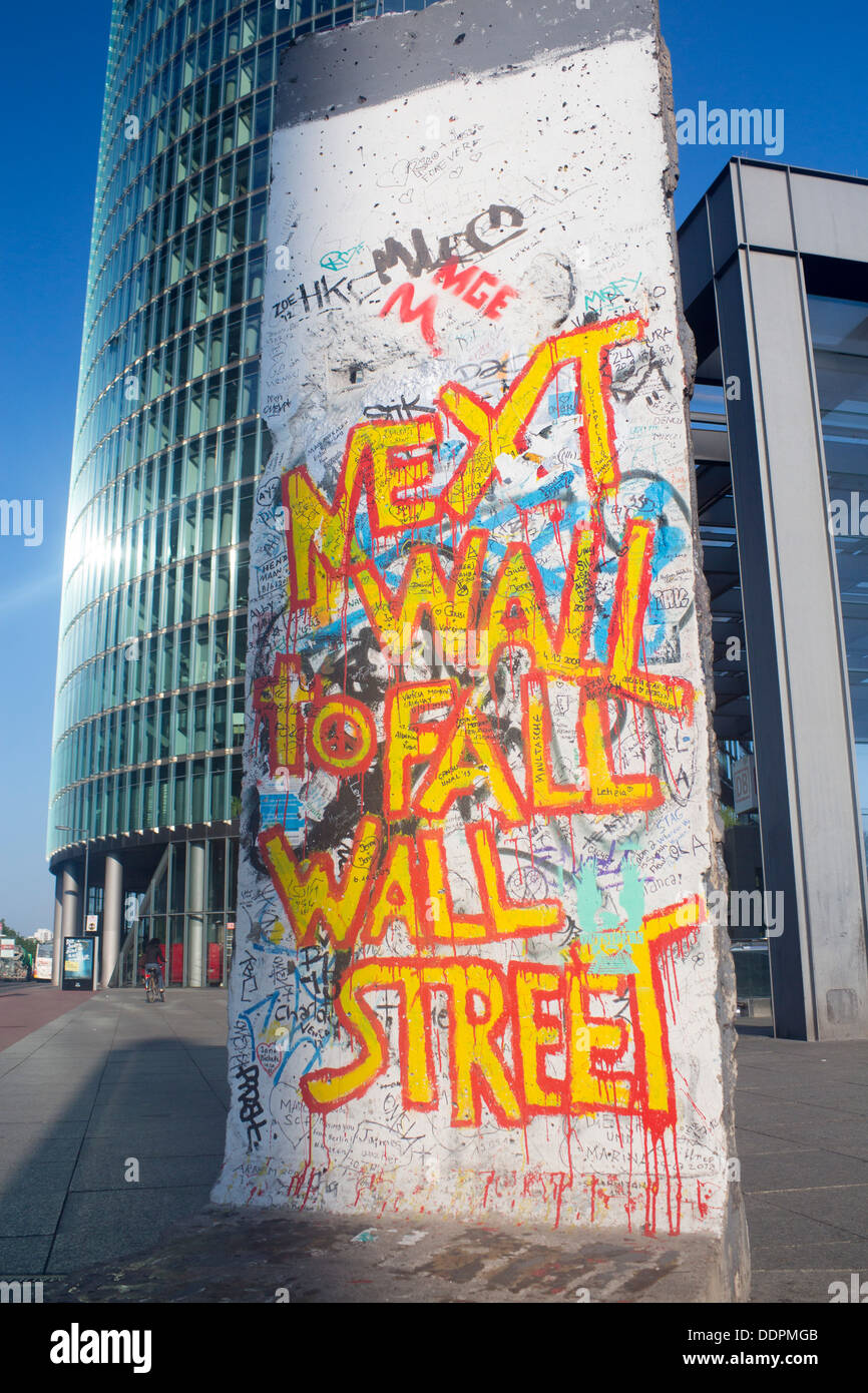 Small remaining section of Berlin Wall on Potsdamer Platz Graffiti 'Next Wall To Fall Wall Street' Berlin Germany Stock Photo