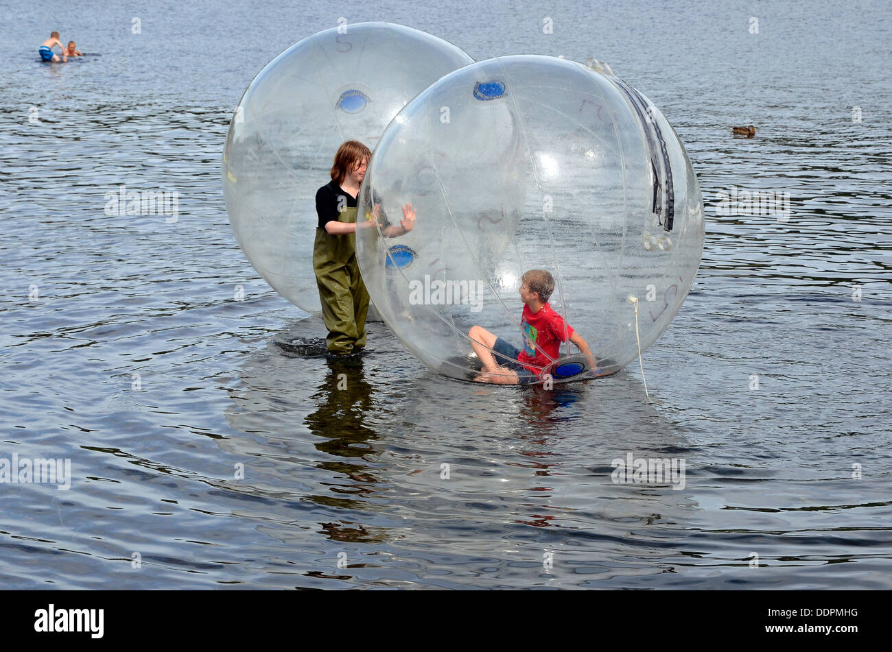 Child in a Waterwalkerz Ball under adult supervision, Coniston Water, Lake District. Stock Photo