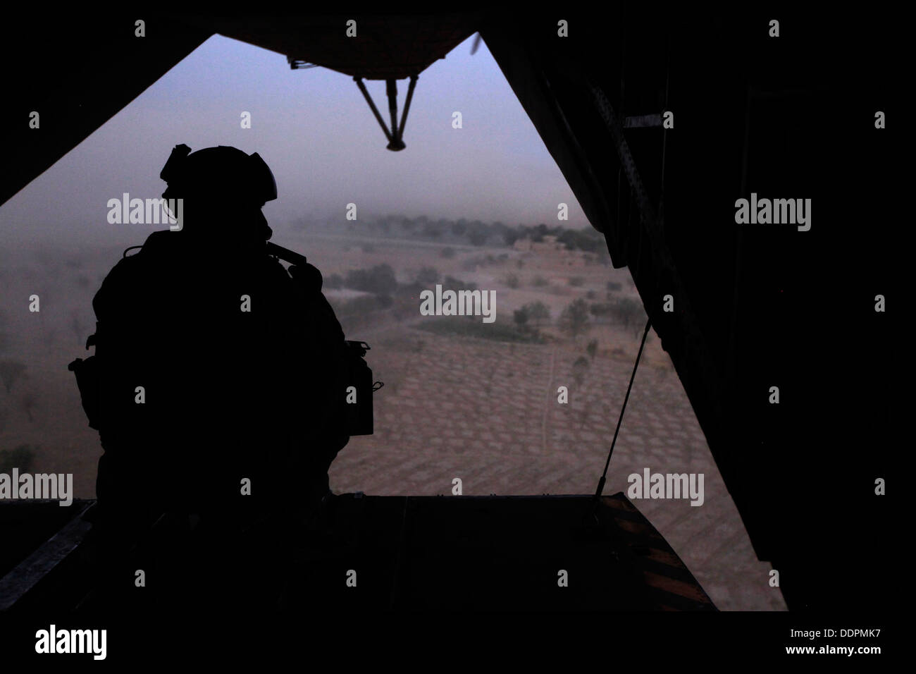 U.S. Marine Corps Cpl. Ryan P. Wells, a crew chief with Marine Heavy Helicopter Squadron 462 (HMH-462), provides aerial security over Helmand province, Afghanistan, Aug. 31, 2013. HMH-462 transported Marines with Golf Company, 2nd Battalion, 8th Marines, Stock Photo