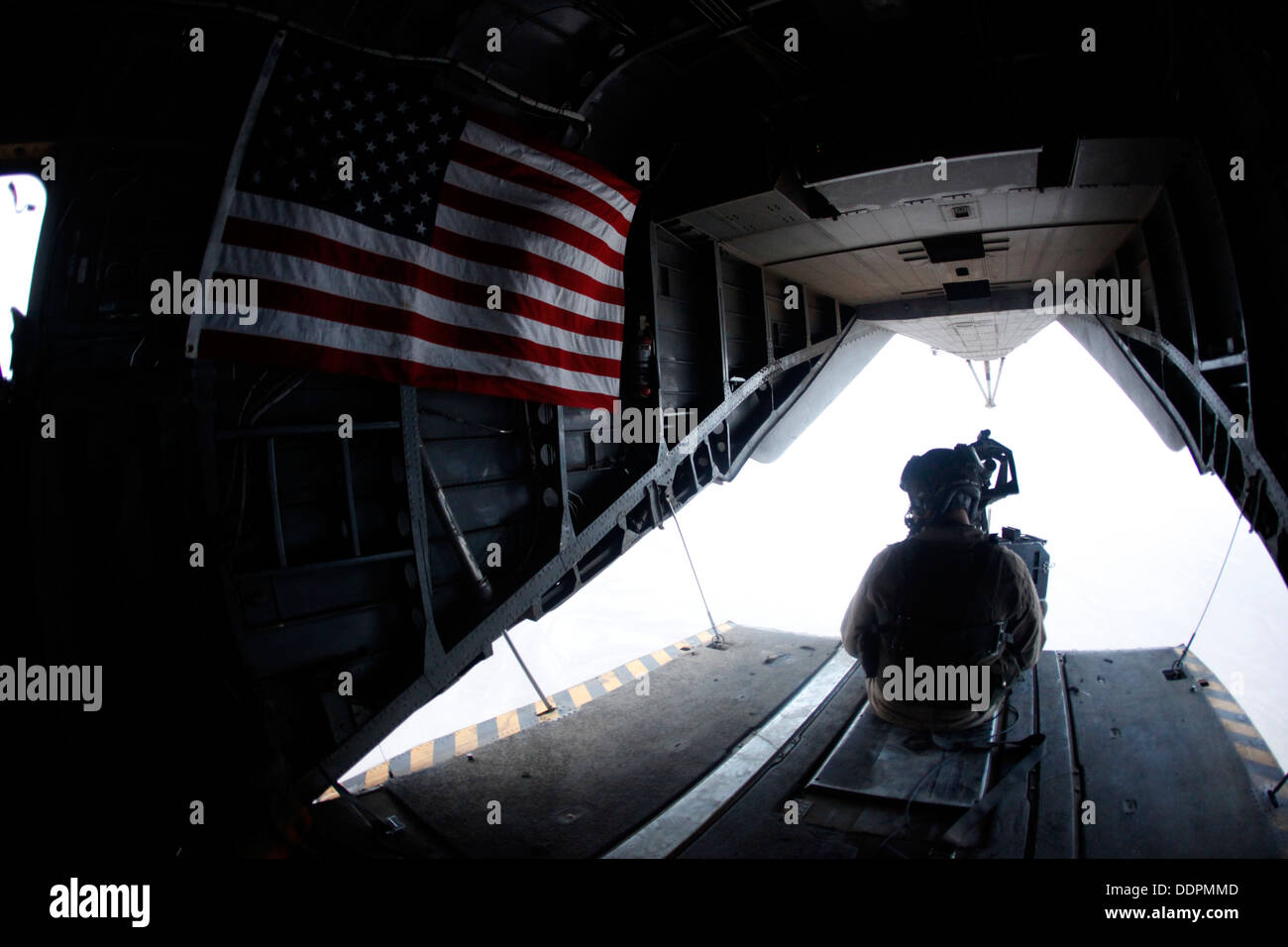 U.S. Marine Corps Cpl. Ryan P. Wells, a crew chief with Marine Heavy Helicopter Squadron 462 (HMH-462), provides aerial security over Helmand province, Afghanistan, Aug. 31, 2013. HMH-462 transported Marines with Golf Company, 2nd Battalion, 8th Marines, Stock Photo