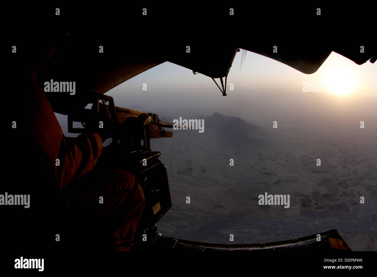 U.S. Marine Corps Cpl. Ryan P. Wells, a crew chief with Marine Heavy Helicopter Squadron 462 (HMH-462), provides aerial security over Helmand province, Afghanistan, Aug. 31, 2013. HMH-462 transported Marines with Golf Company, 2nd Battalion, 8th Marines, Stock Photo