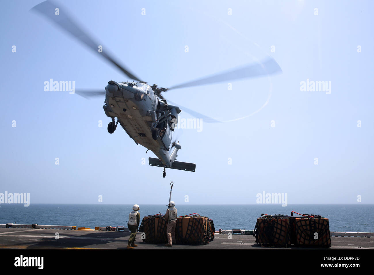 Marines from the 26th Marine Expeditionary Unit hook cargo to an MH-60S Sea Hawk helicopter aboard the amphibious assault ship USS Kearsarge (LHD 3) during a replenishment at sea. Kearsarge is the flagship for the Kearsarge Amphibious Ready Group and, wit Stock Photo