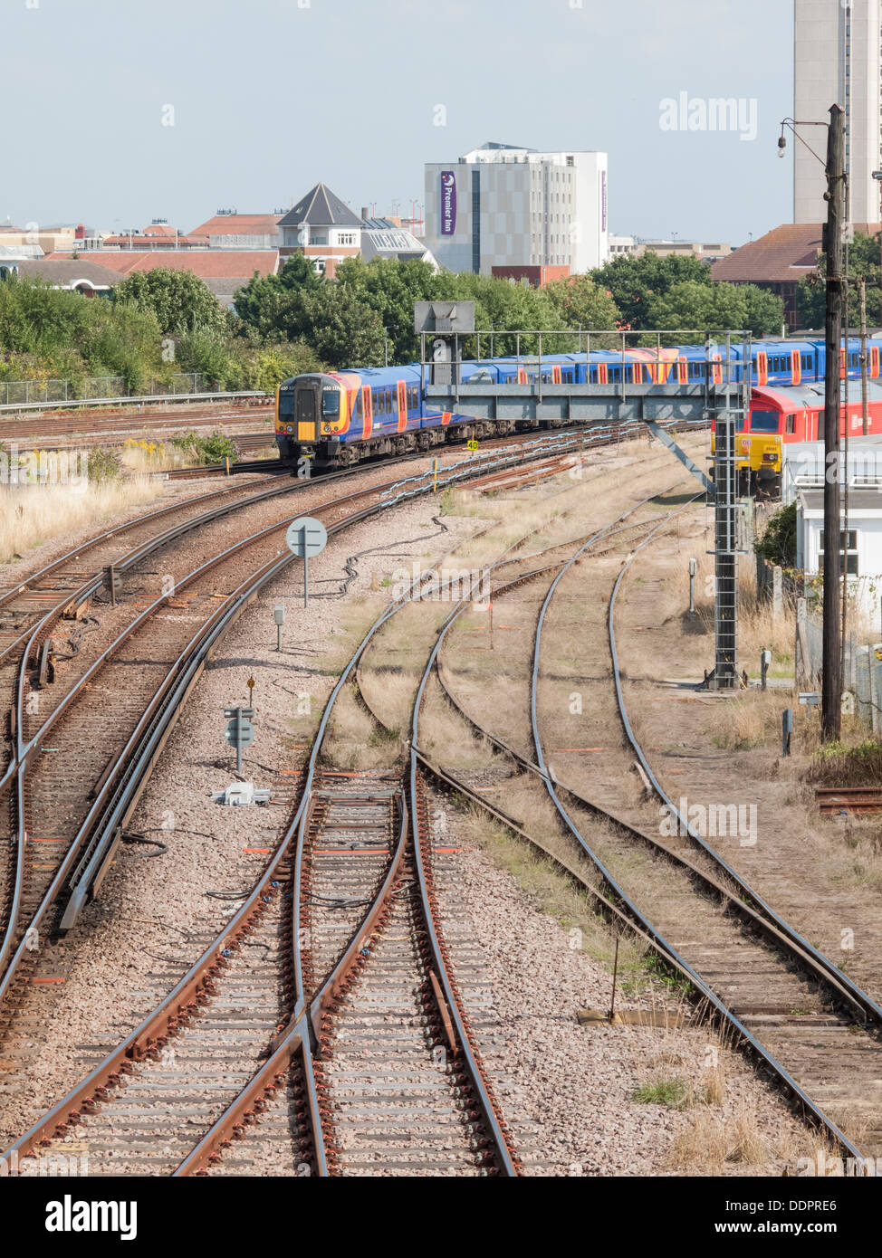 Railway tracks leading towards Woking, Surrey, England with South West Trains passenger train approaching Woking station Stock Photo
