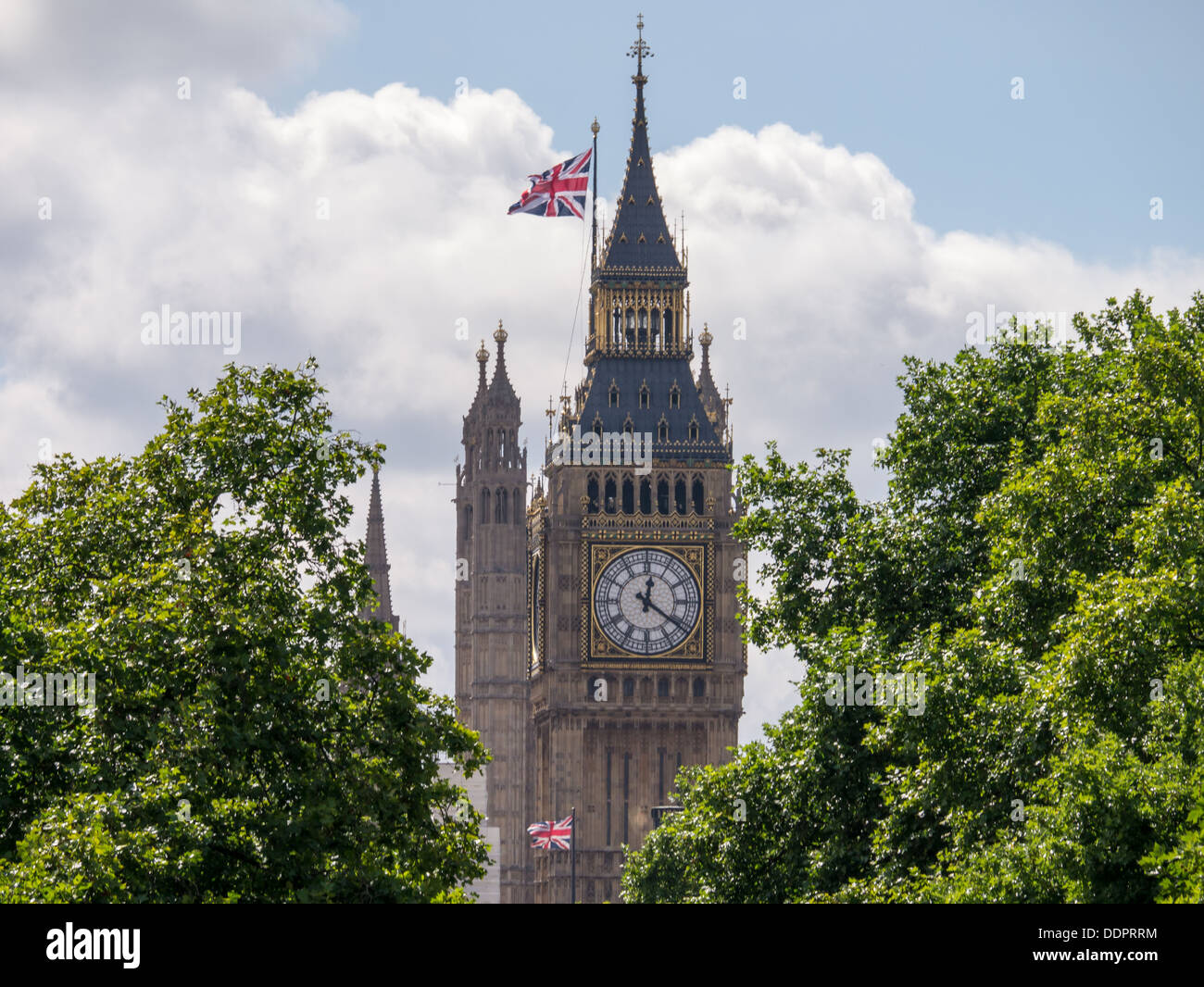 Union Jack flags fly on Big Ben at the Houses of Parliament in Westminster, London Stock Photo