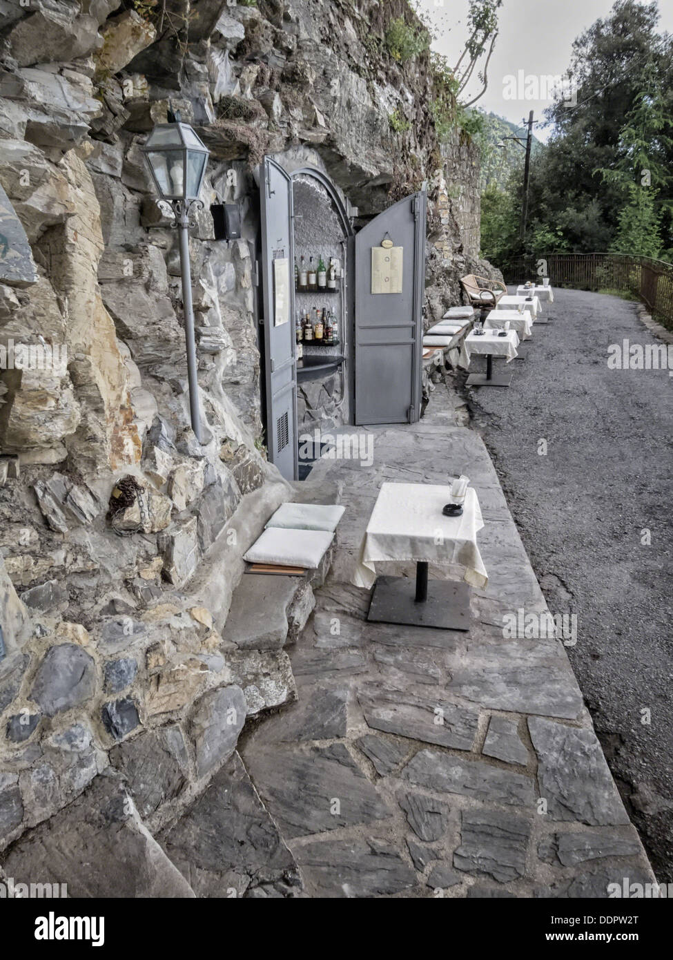 Bar built into stone hillside, with outdoor tables and wicker chairs at San Rocco on path between San Fruttuoso and Camogli , Li Stock Photo