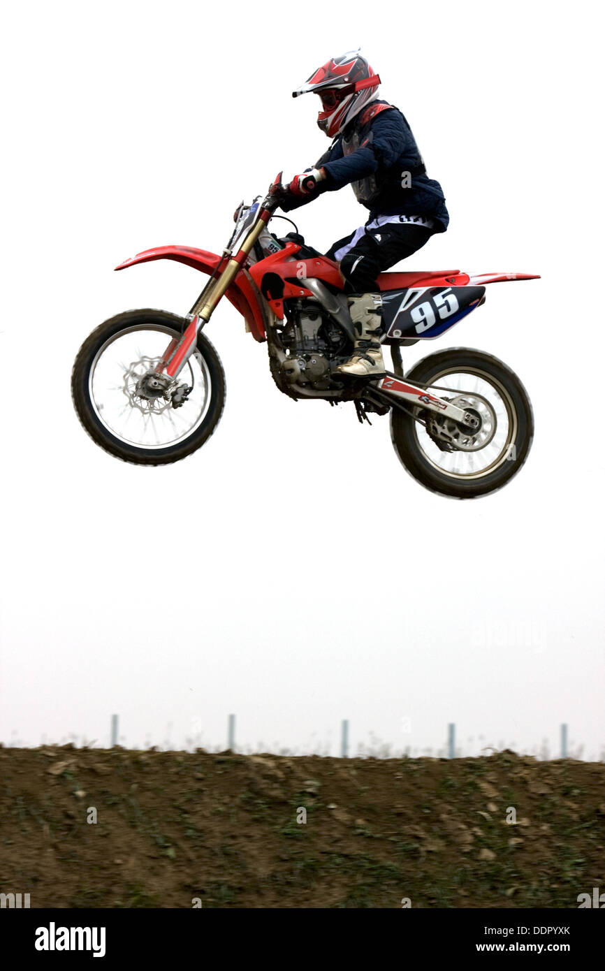 Single motocross rider flying through air, side view Stock Photo