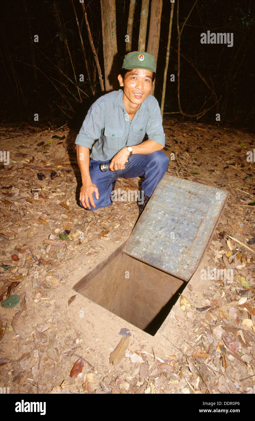 Soldier showing an entrance to the Cu Chi tunnels, used by the Viet