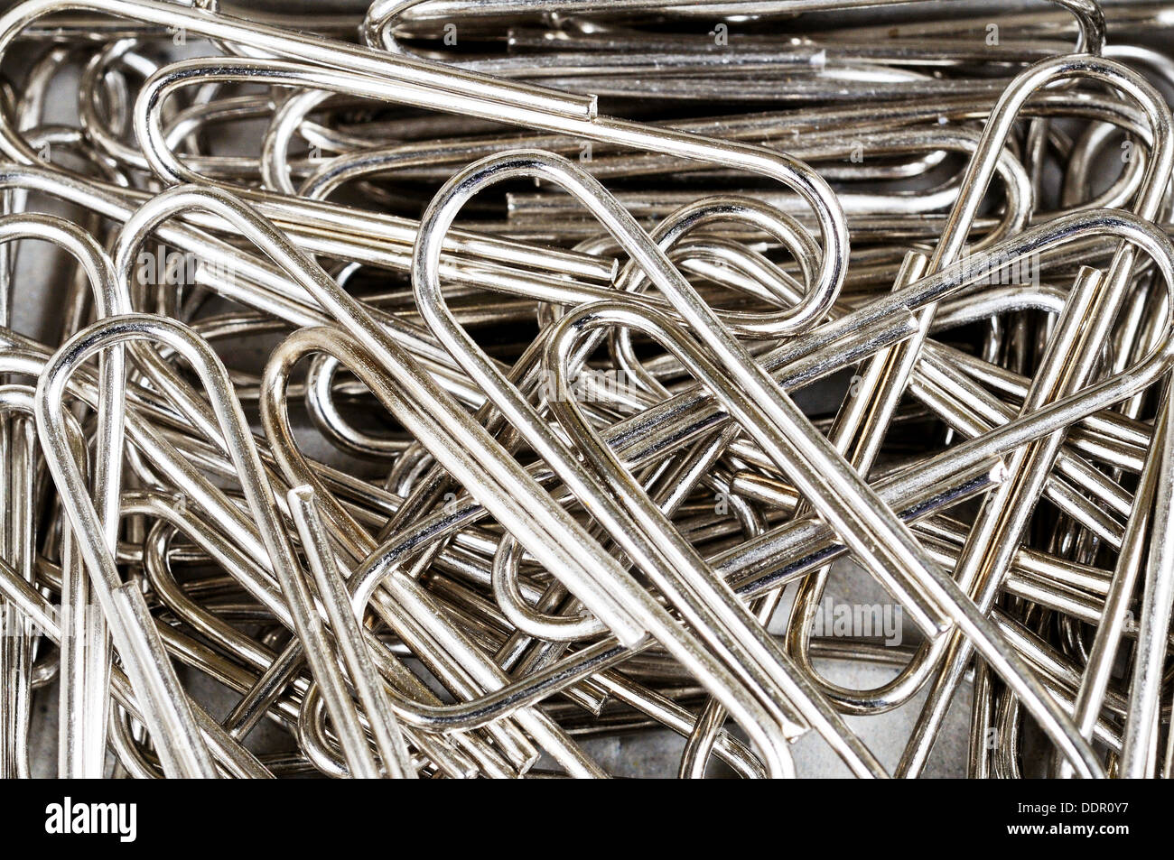 Scattered paper clips office equipment background. Stock Photo