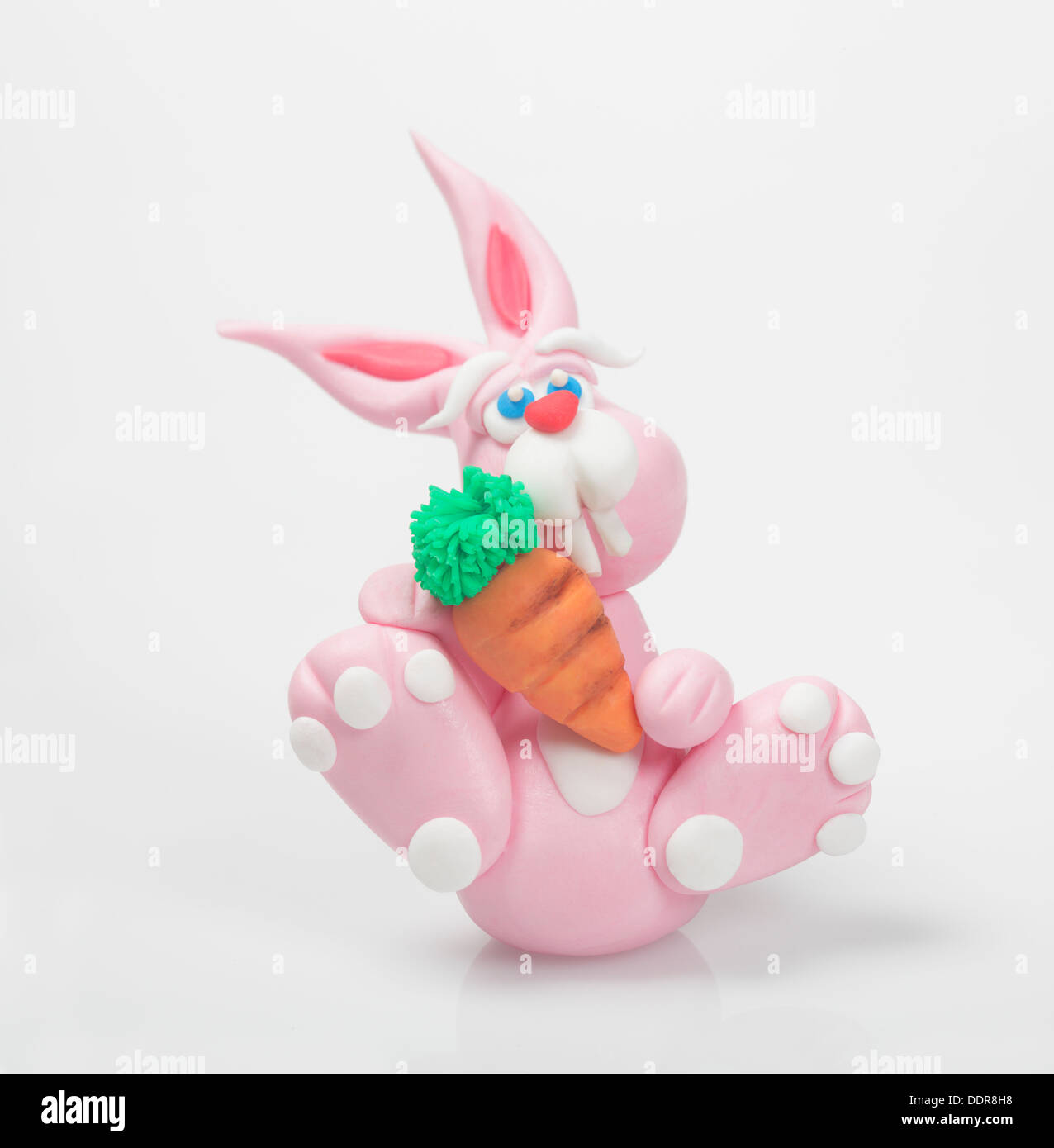 Funny rabbit for a Cake design project, the rabbit is pink and holds a carrot in his hand, perfect decoration for easter. Stock Photo