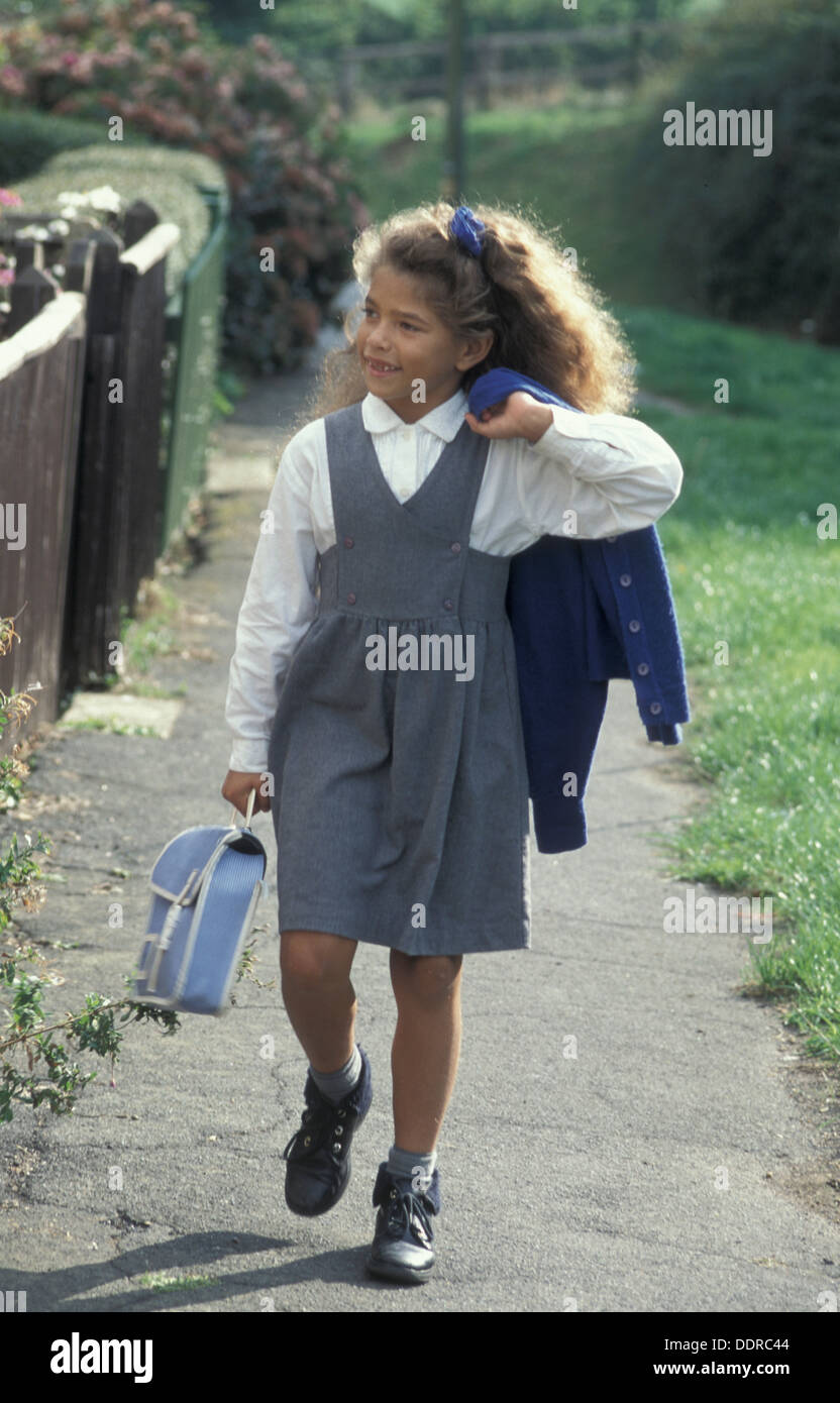 little girl in school uniform walking to or from school Stock Photo - Alamy