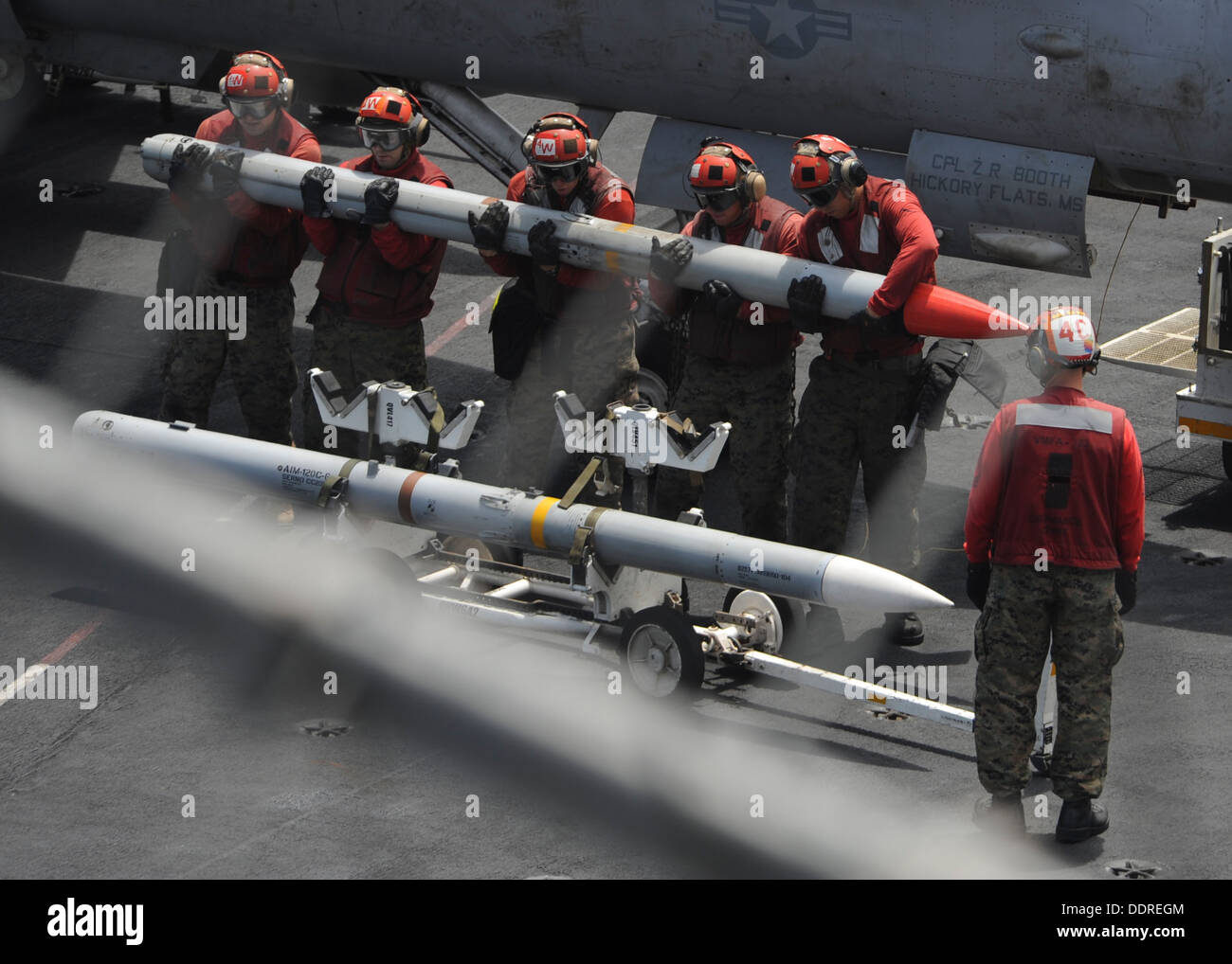 Aviation ordnancemen assigned to the Death Rattlers of Marine Fighter Attack Squadron (VMFA) 323 lift a missile on the flight deck of the aircraft carrier USS Nimitz (CVN 68). The Nimitz Carrier Strike Group is deployed to the U.S. 5th Fleet area of respo Stock Photo