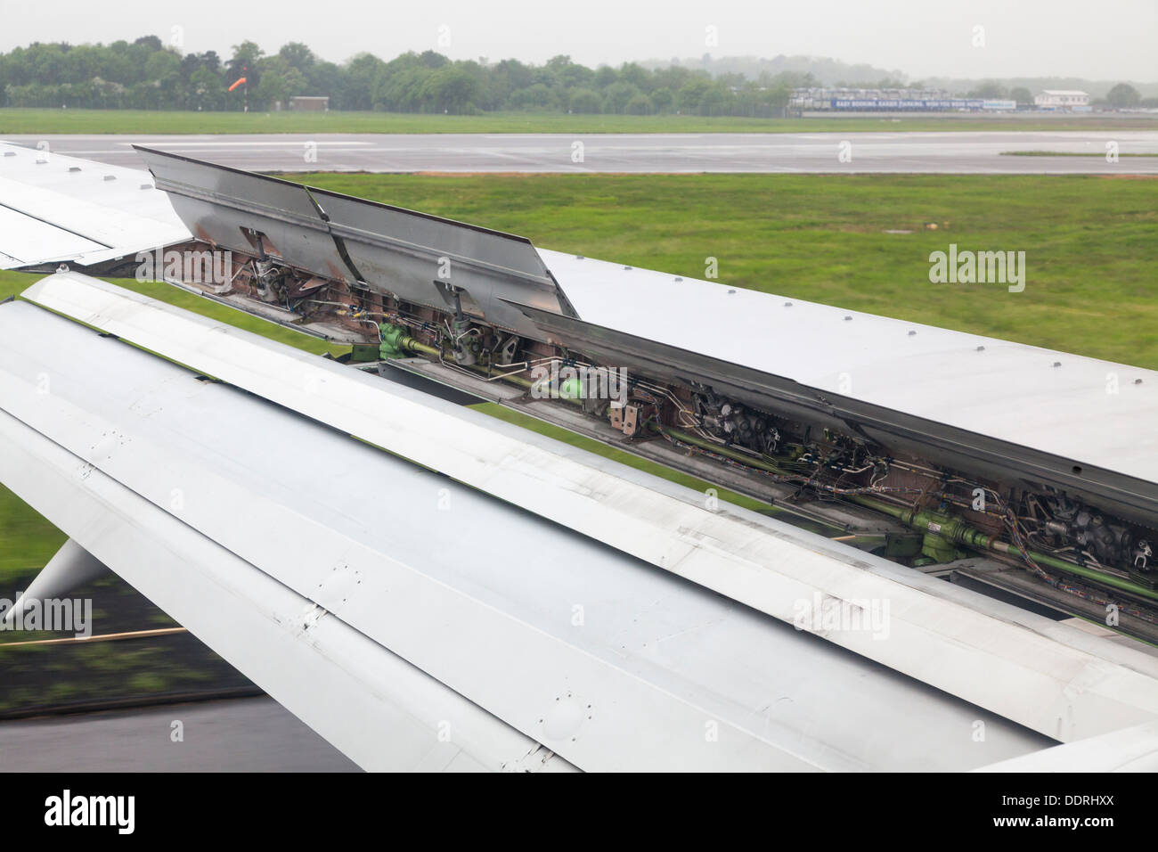 aircraft wing spoiler deployed during landing showing hydraulics Stock Photo