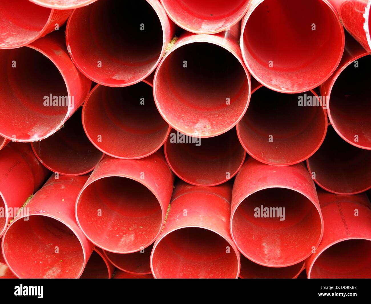 Many red plastic pipes stacked Stock Photo Alamy