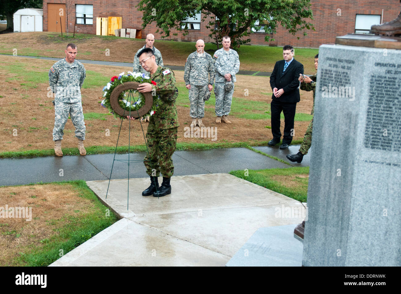 Maj. Gen. Omori (center), deputy commanding general, 4th Division, Northern Army, Japanese Ground Self-Defense Force, places a wreath at the Arrowhead Brigade Memorial as a sign of respect to the fallen Soldiers of the Arrowhead Brigade, Sept. 3, 2013. So Stock Photo