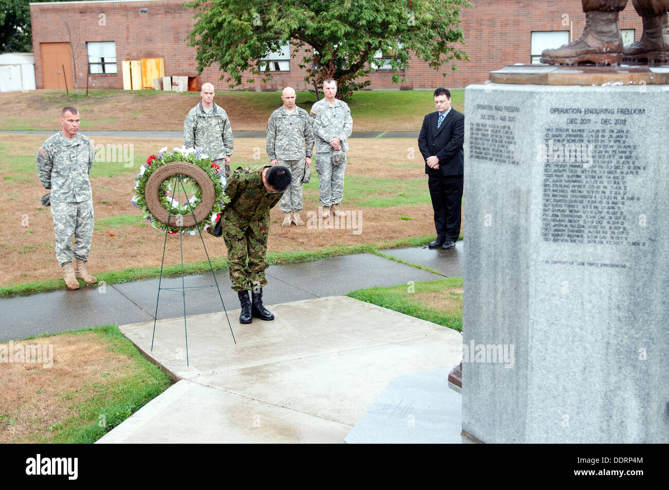 Maj. Gen. Omori (center), deputy commanding general, 4th Division, Northern Army, Japanese Ground Self-Defense Force, bows before the Arrowhead Brigade Memorial as a sign of respect to the fallen Soldiers of the Arrowhead Brigade, Sept. 3, 2013. Soldiers Stock Photo