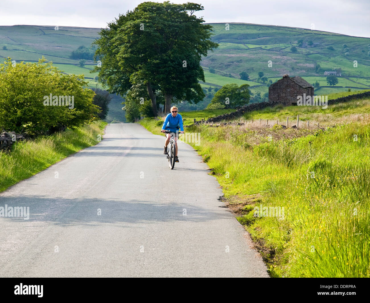 Female cycling near Gradbach in the Staffordshire Moorlands, Peak District National Park Stock Photo