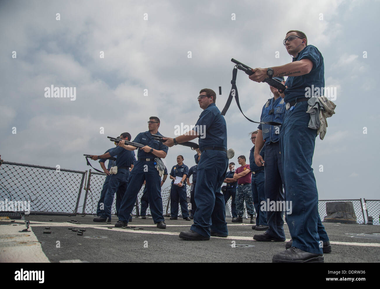 USS Stout (DDG 55) fire M500 shotguns during a practical weapons course. Stout is on a scheduled deployment supporting maritime Stock Photo