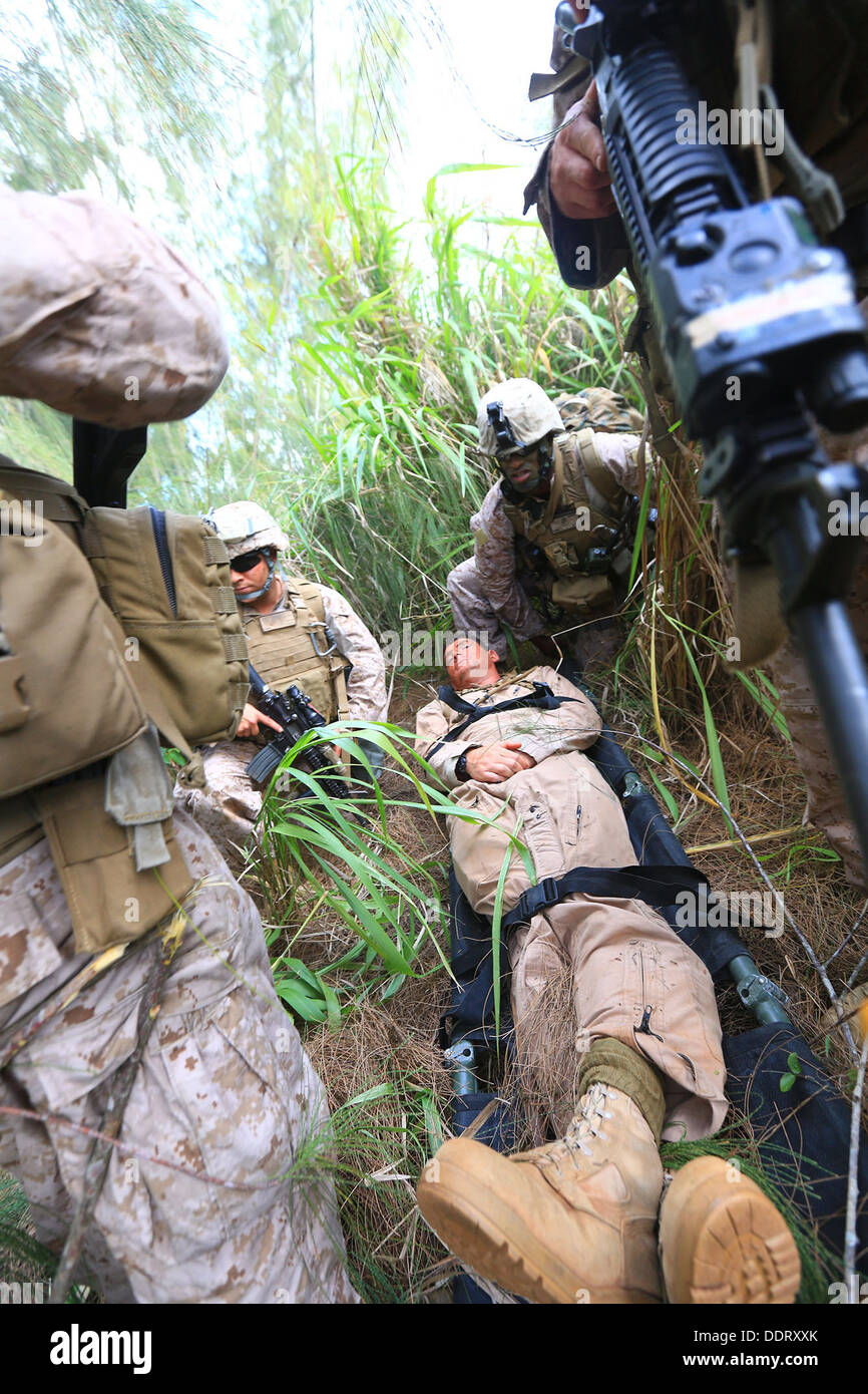 ABOARD USS BOXER (LHD 4) – Marines from 81mm Platoon, TRAP Section, Weapons Company, Battalion Landing team 1/4, 13th Marine Expeditionary Unit, render first aid to a simulated casualty while on a Tactical Recovery of Aircraft Personnel (TRAP) training ex Stock Photo