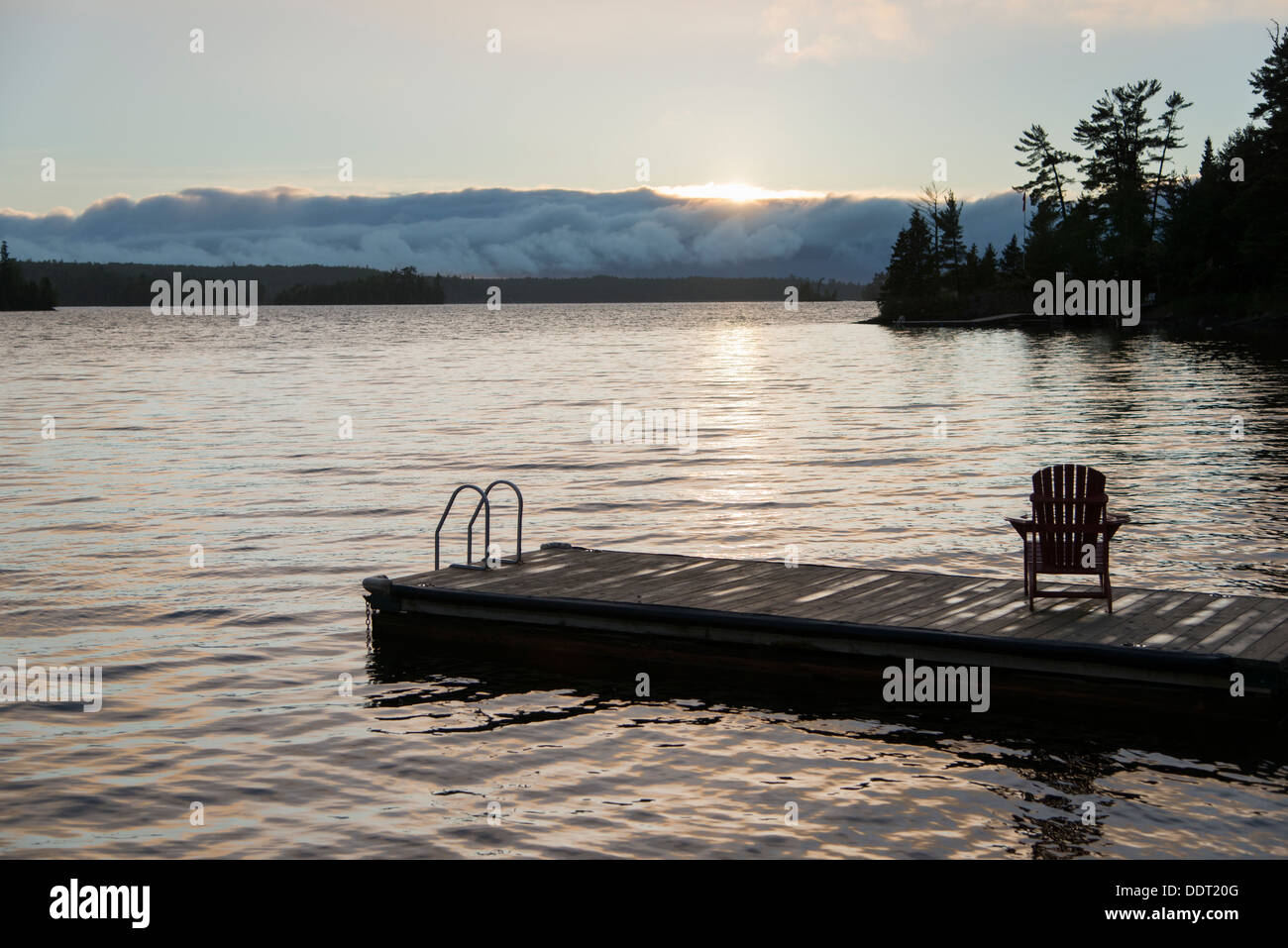 Adirondack chair on dock at lake, Lake Of The Woods, Keewatin, Ontario ...