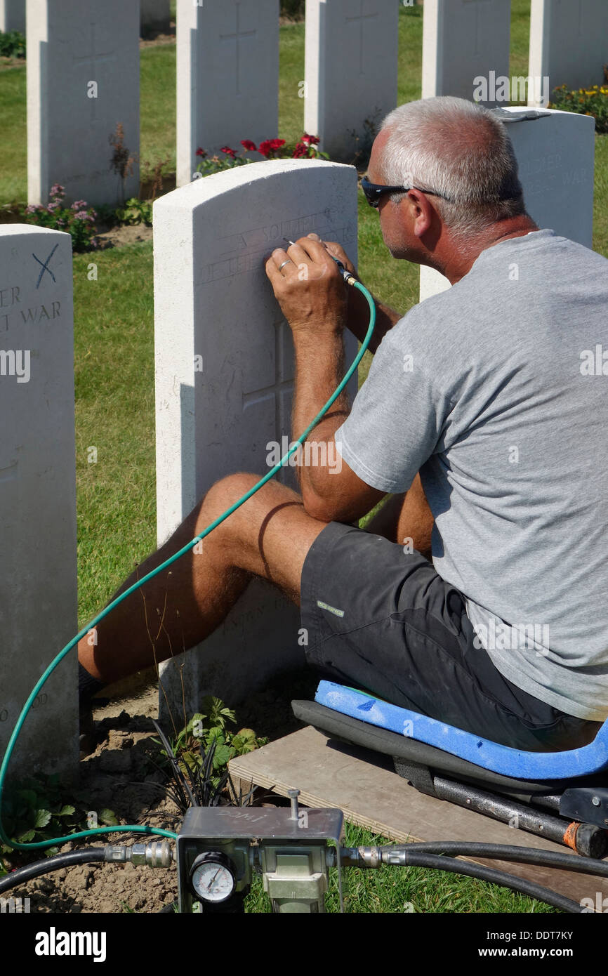 Engraver restoring headstone at Tyne Cot Cemetery of the Commonwealth War Graves Commission for World War One British soldiers Stock Photo