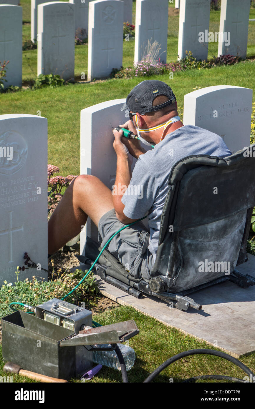 Engraver restoring headstone at Tyne Cot Cemetery of the Commonwealth War Graves Commission for World War One British soldiers Stock Photo