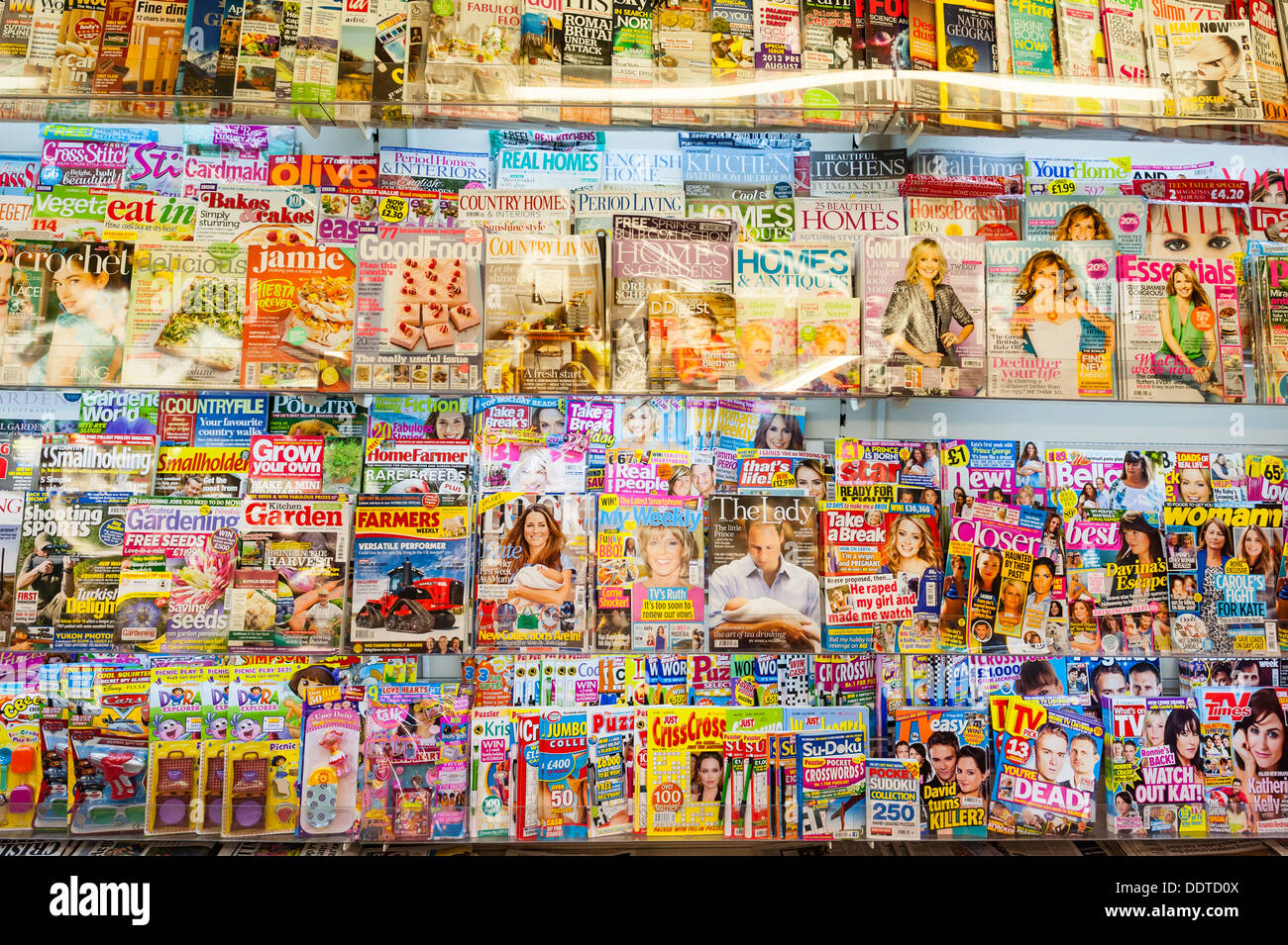 Magazines for sale on a shelf in a newsagent shop store in the Uk Stock Photo