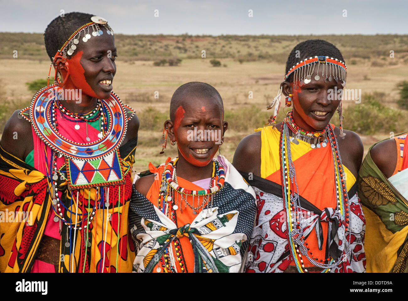 Masai women wearing colorful traditional dress, singing in a village near the Masai Mara, Kenya, Africa Stock Photo