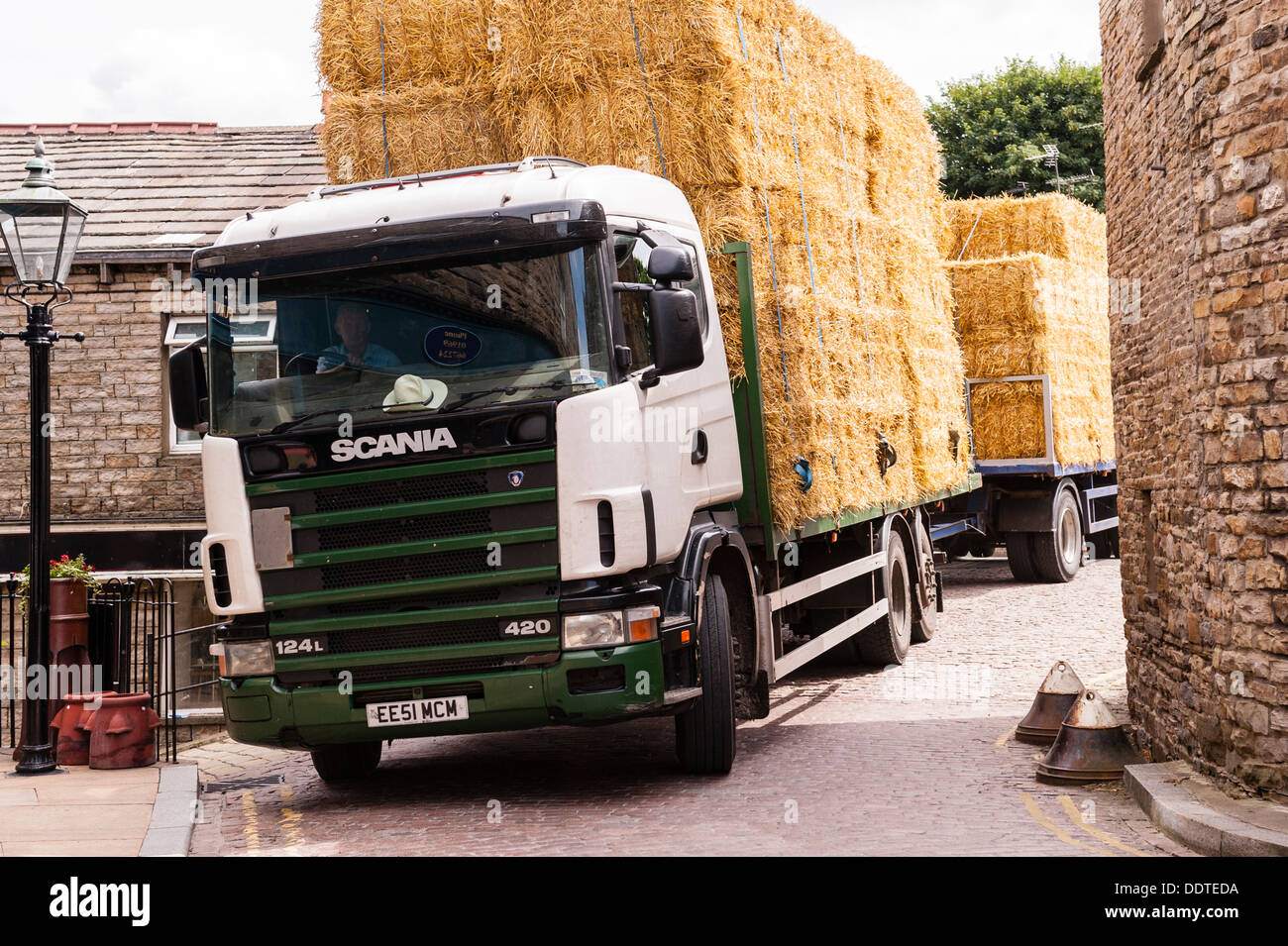 A Scania articulated lorry carrying straw bales driving through the narrow streets of Hawes in Wensleydale , North Yorkshire, Uk Stock Photo