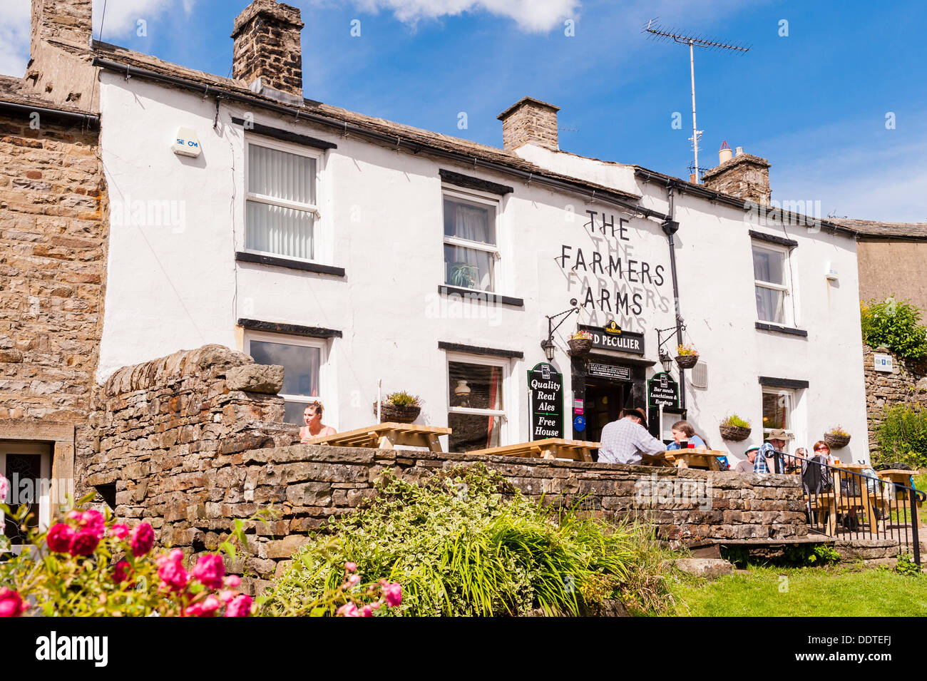 The Farmers Arms pub with people sitting outside at Muker in Swaledale , North Yorkshire , England, Britain, Uk Stock Photo