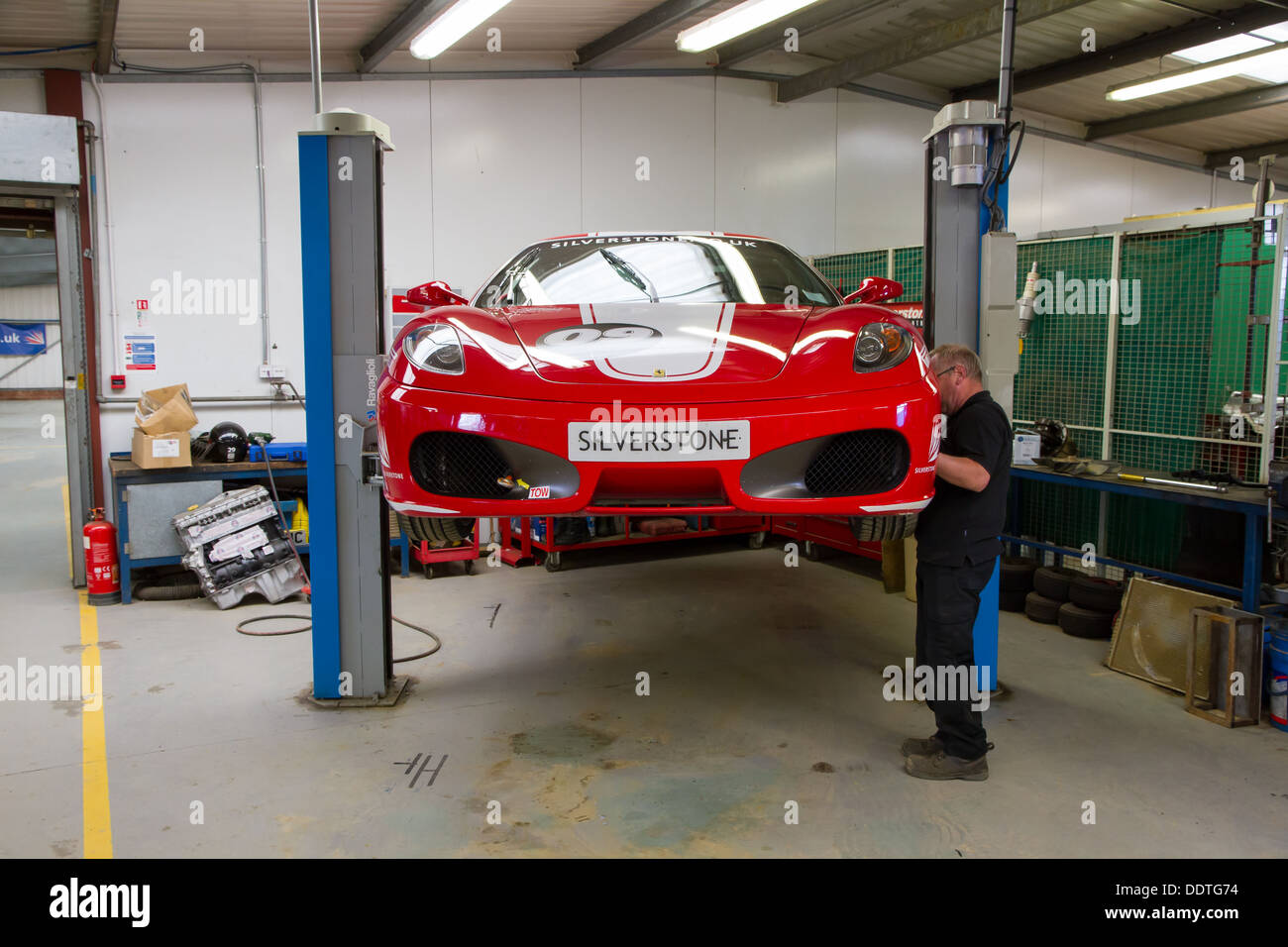 Mechanic working on a Ferrari F430 track car in the garage at Silverstone Racing Circuit. Stock Photo