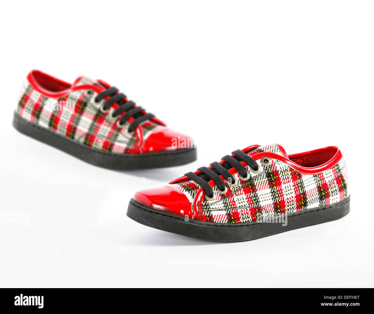 beautiful red women's shoes in a cage, plaid on a white background, isolated Stock Photo