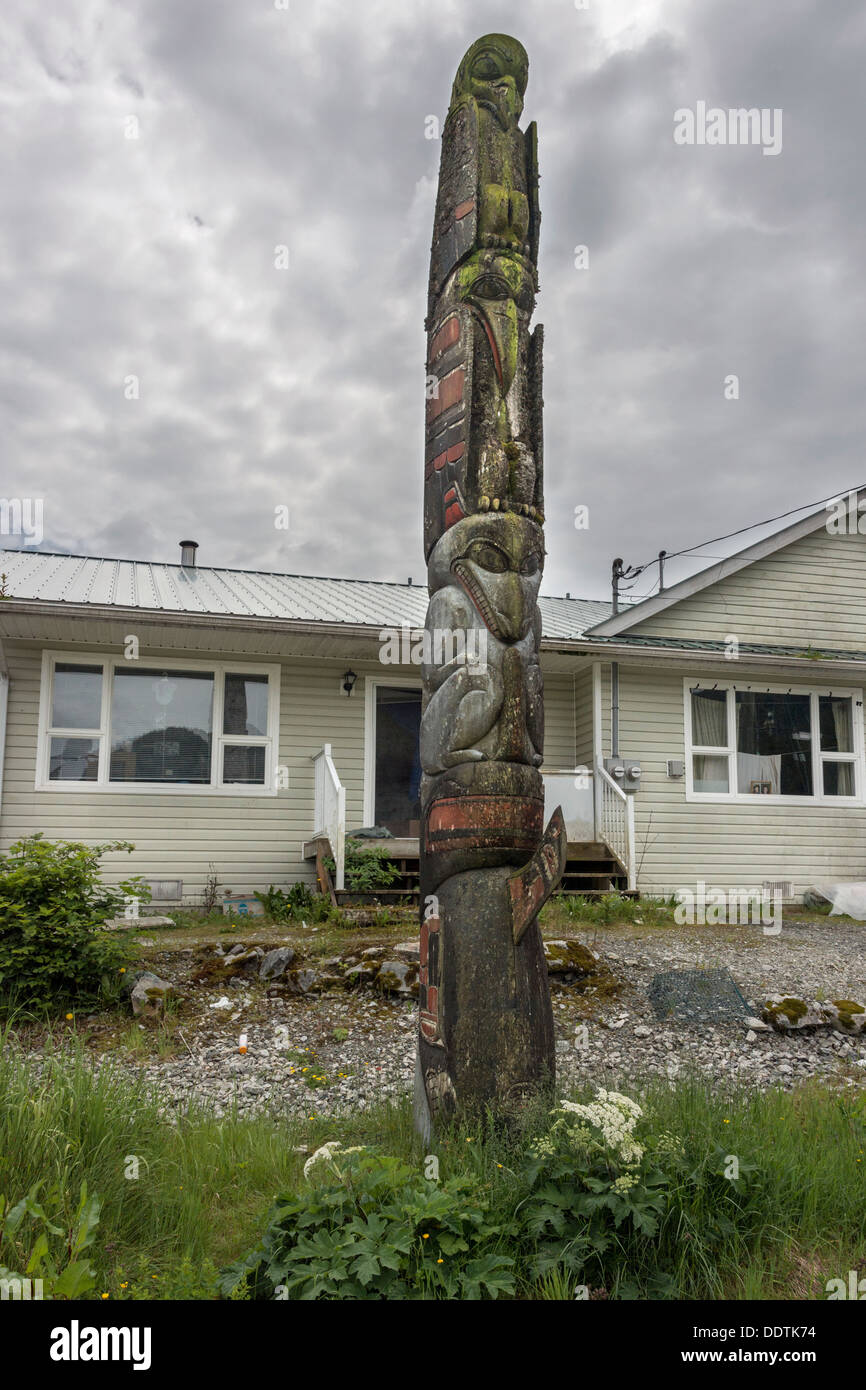 Old totem pole in front of house at Klemtu Village, Swindle Island