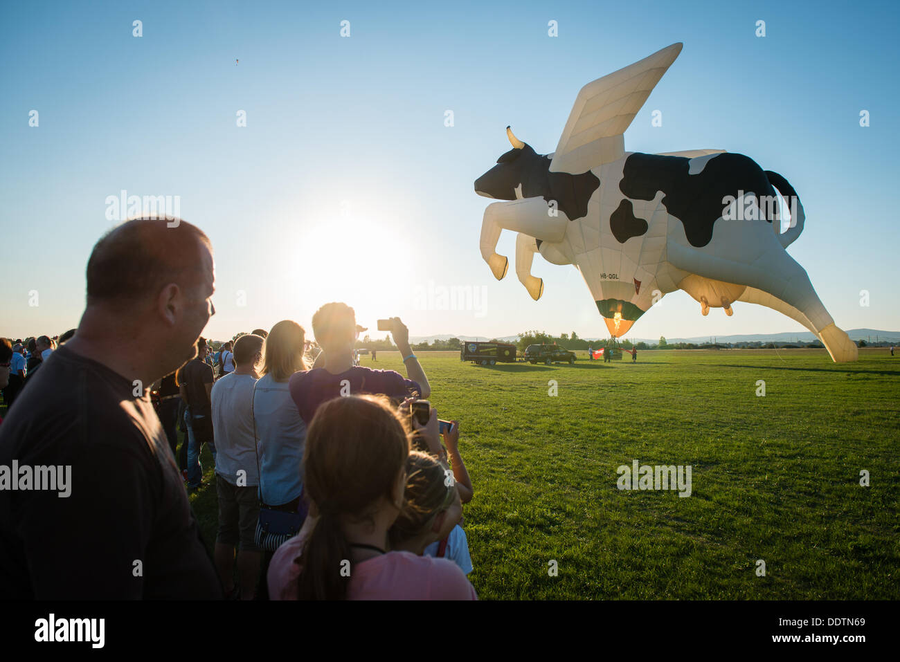 Piestany, Slovakia. 6th September 2013. Crowds watch as Swiss crew blast the flame into cow shape balloon during 1st Balloon megafiesta on September 6th, 2013 in Piestany, Slovakia Credit: Lubos Paukeje/Alamy Live News Stock Photo