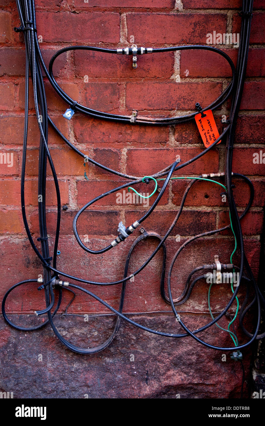 Wires against a brick wall Stock Photo