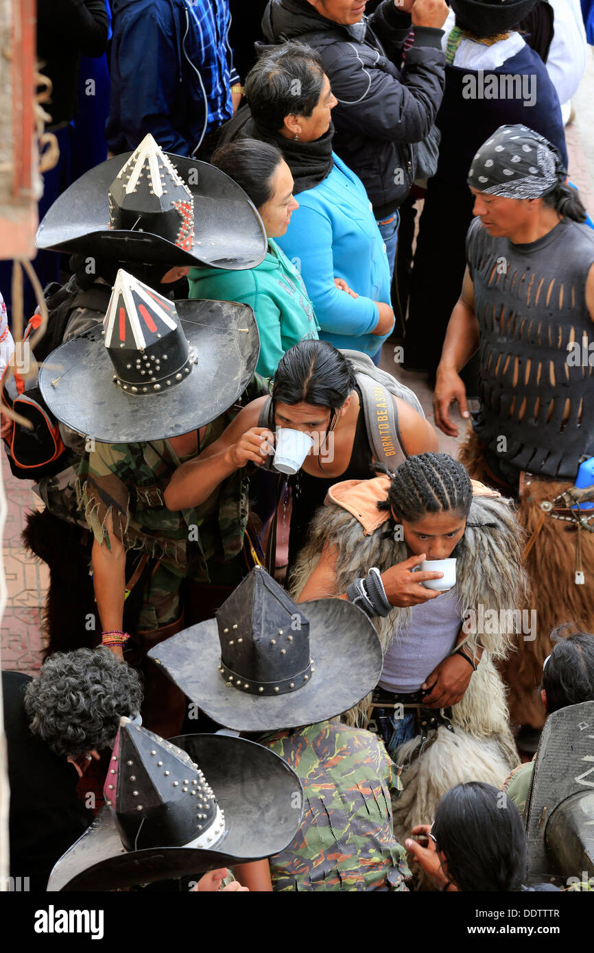 Thirsty men from an indigenous community take a drink of water during Inti Raymi festivities in Cotacachi, Ecuador Stock Photo