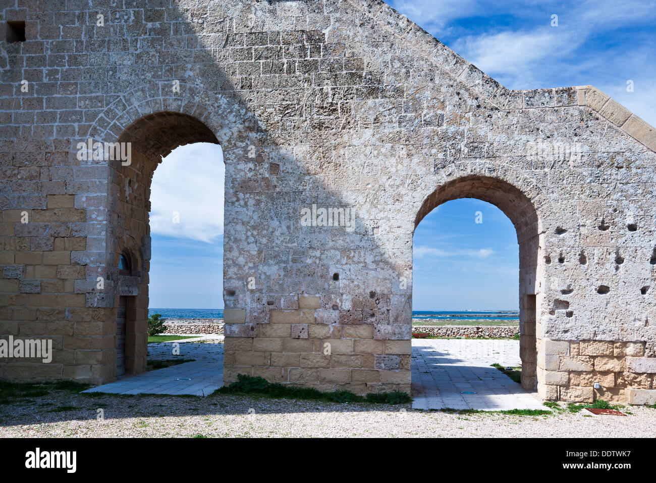Detail view of Torre Lapillo, 16th century tower coastline defense, with coastline framed by arched stairway leading to square s Stock Photo