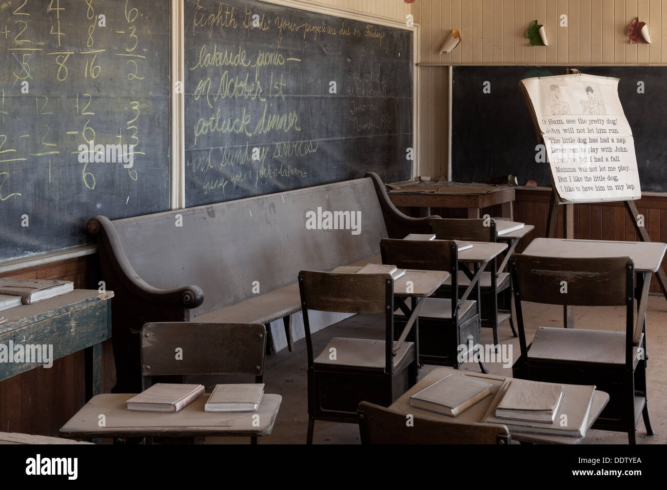 Schoolroom with original old desks and chairs, chalkboard,  desaturated image,  Bodie pioneer village, California Stock Photo