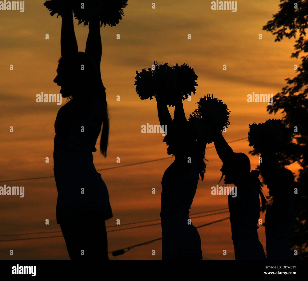 Sept. 6, 2013 - Hebron, Kentucky, U.S - Simon Kenton High School cheerleaders  cheer at the start of their game with Conner High School at  Conner On Friday September 6, 2013 in Hebron,Kentucky as the sun sets behind them. (Credit Image: © Ernest Coleman/ZUMAPRESS.com) Stock Photo
