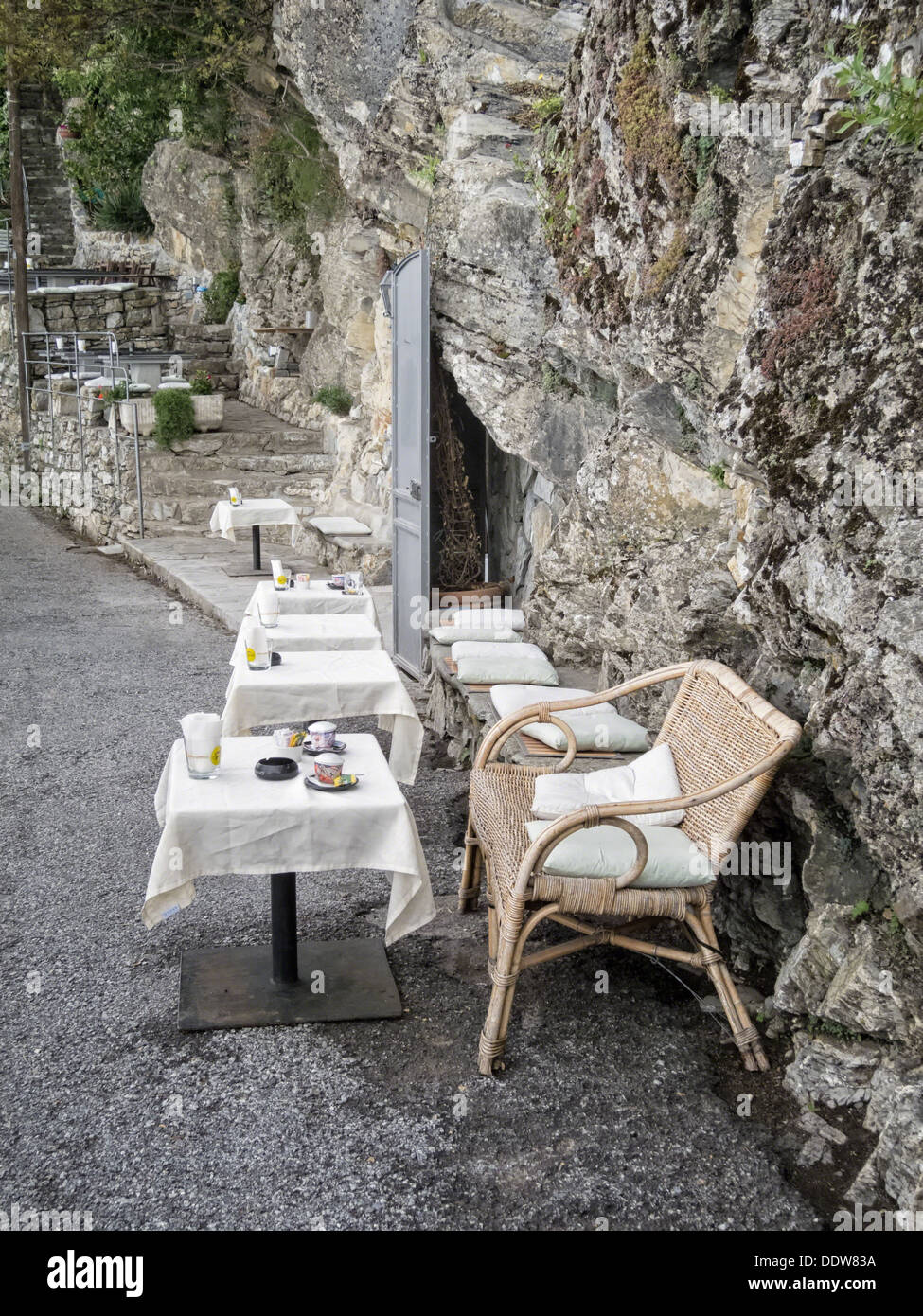 Bar built into stone hillside, with outdoor tables and wicker chairs at San Rocco on path between San Fruttuoso and Camogli , Li Stock Photo