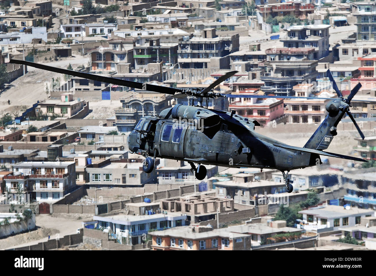 A US Army UH-60L Black Hawk helicopter flies over a residential area of Kabul during a mission September 4, 2013 in Kabul, Afghanistan. Stock Photo