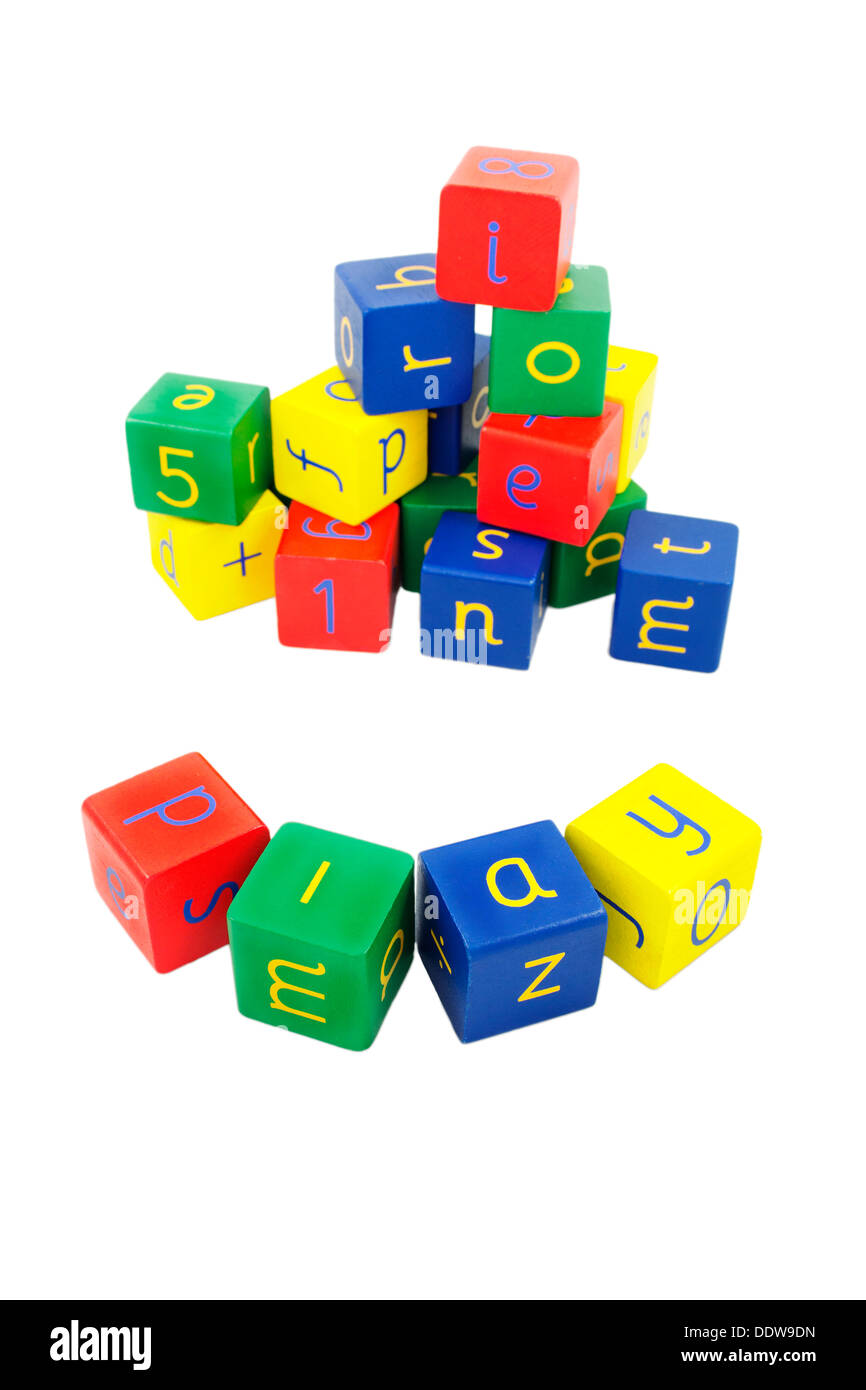 child's letter and number blocks in primary colours on a white background. The arrangement at the front spells 'play' Stock Photo